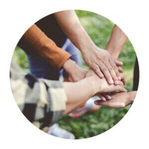 Hands stacked together in a team gesture.